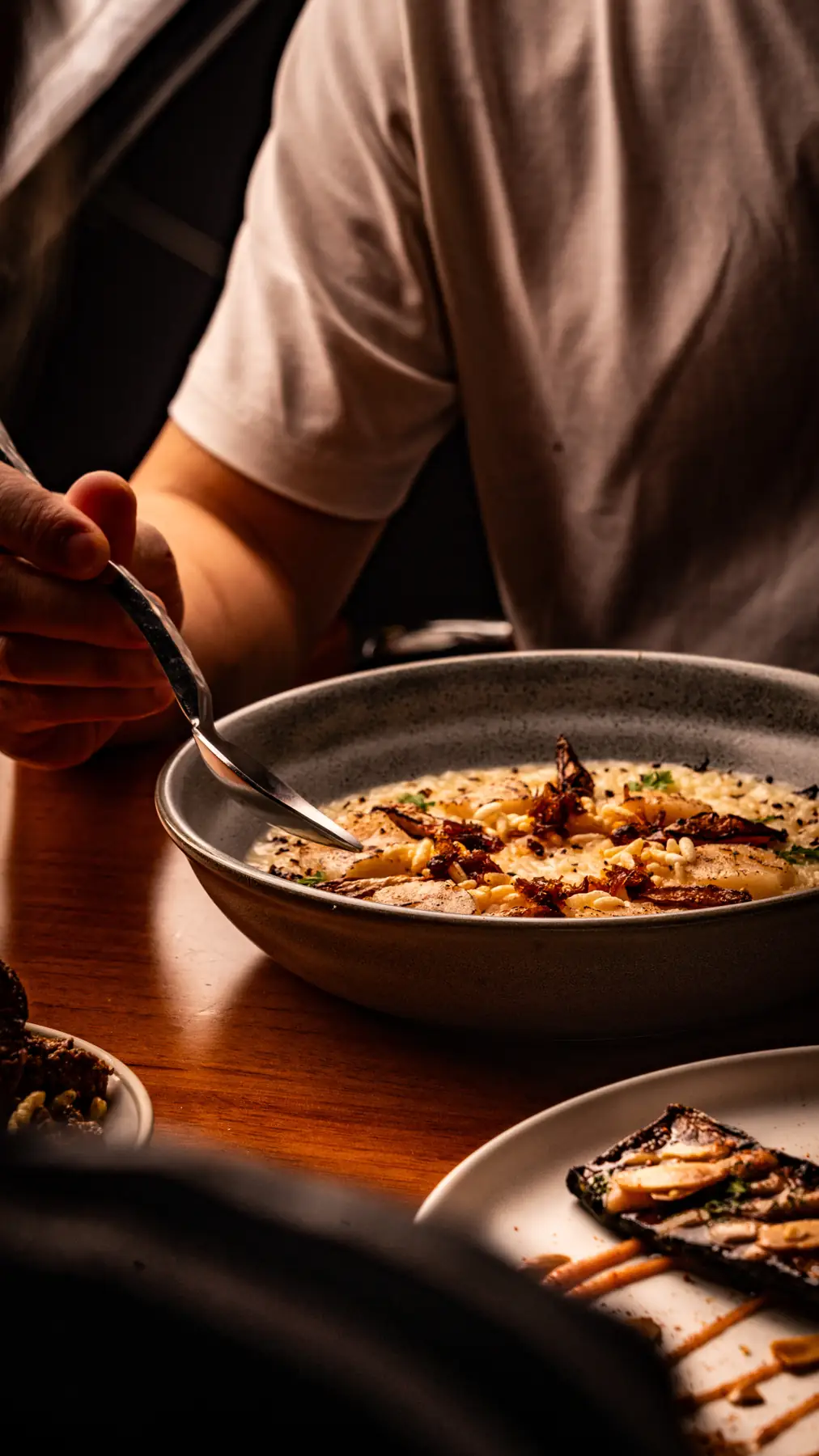 Man eating creamy risotto at To;asta.